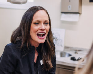 Dental therapist demonstrating oral posture technique during visit
