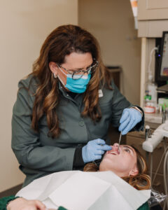 Dentist performing oral exam during wellness-focused dental checkup