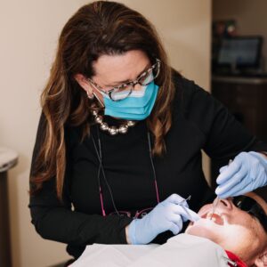 Dental hygienist holding pink dental model with big smile