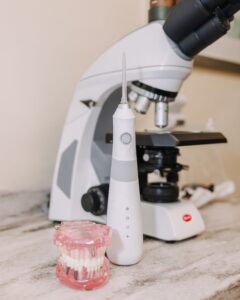 Oral irrigator and microscope on dental counter.