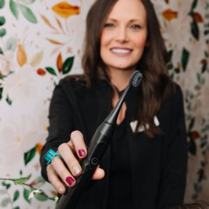 Dental professional holding an electric toothbrush to demonstrate proper oral hygiene