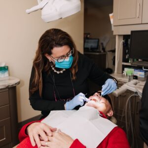 Dental professional examining a patient’s teeth and gums during a dental visit